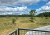 view of the mima mounds and a paved walkway from an observation deck with a metal mesh railing